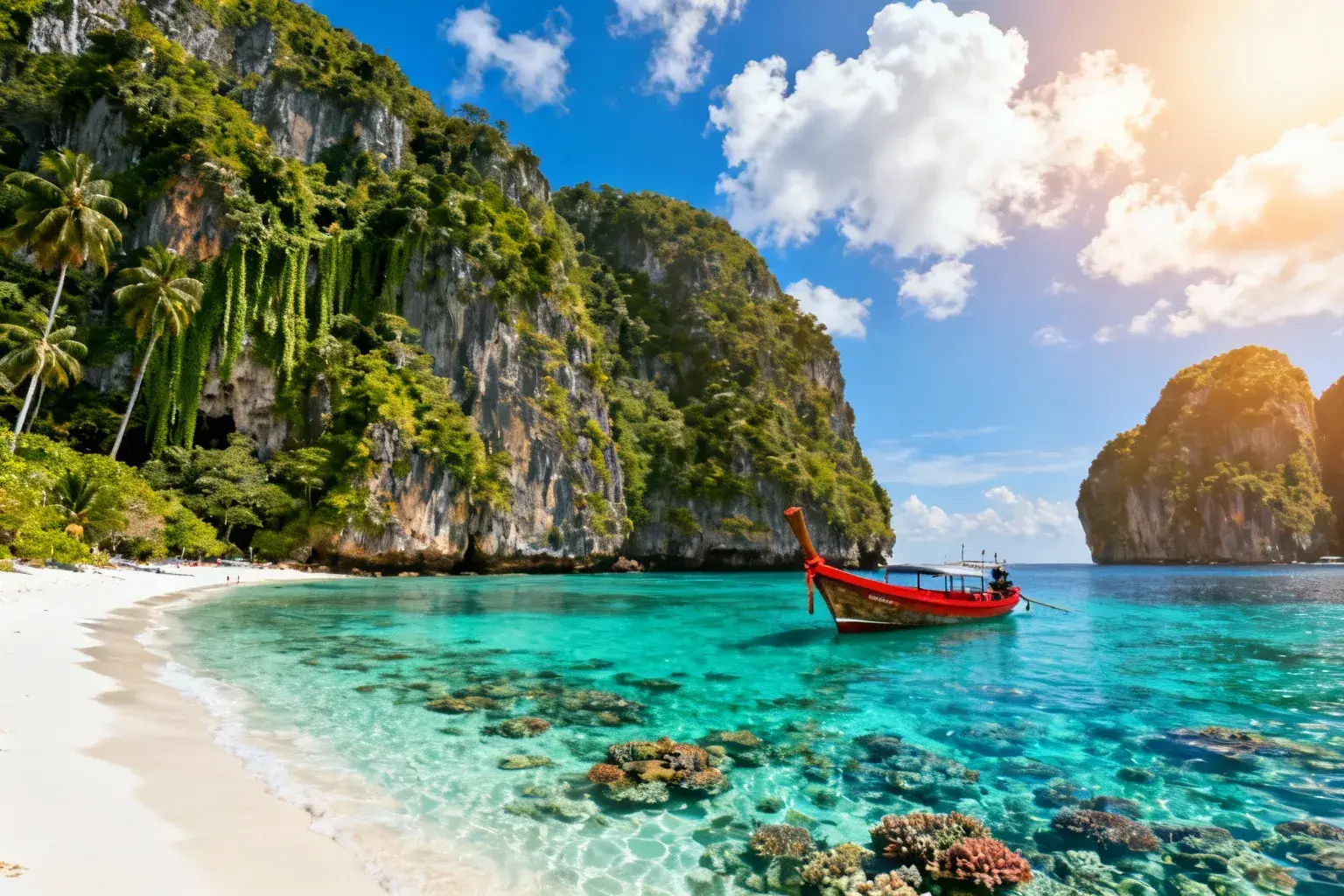 Plage de sable blanc en Thaïlande avec eau cristalline turquoise, coraux visibles et falaises calcaires couvertes de jungle